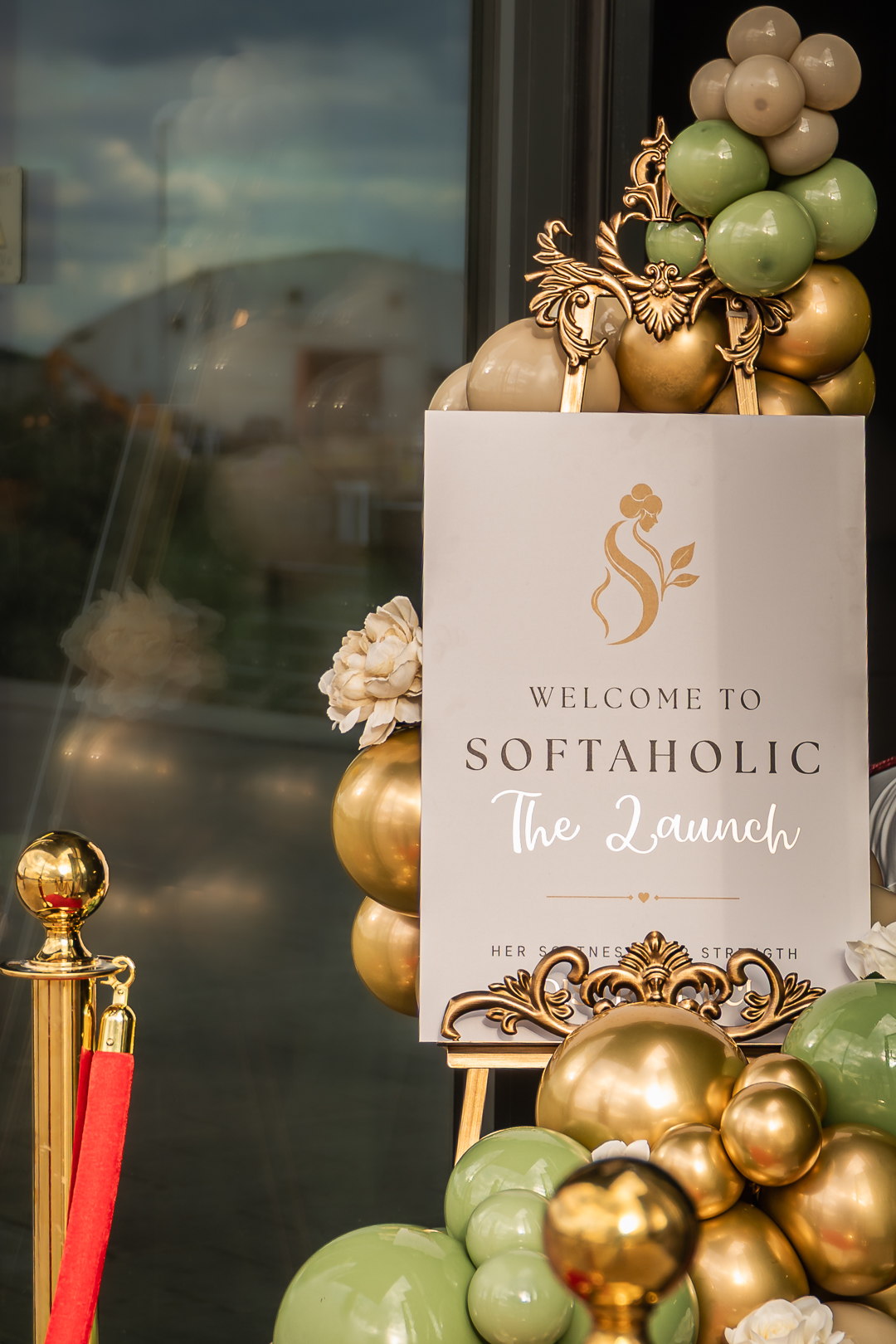 Welcome to Softaholic — The Launch signage with olive and gold balloons